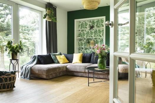 Green living room with brown couch.