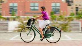 Brunette woman riding bicycle around city
